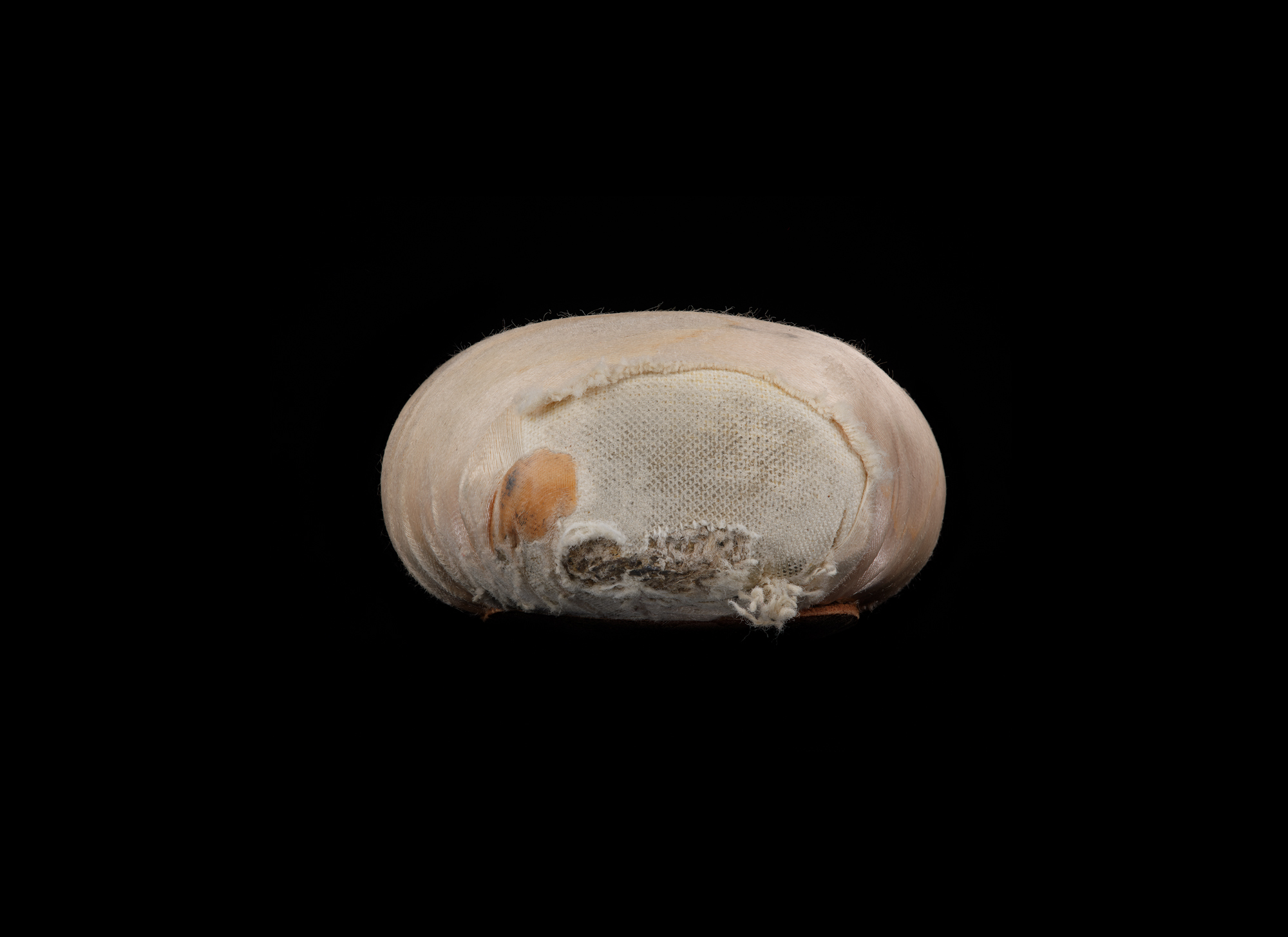 Close-up of the eroded toe of a worn pink pointe shoe