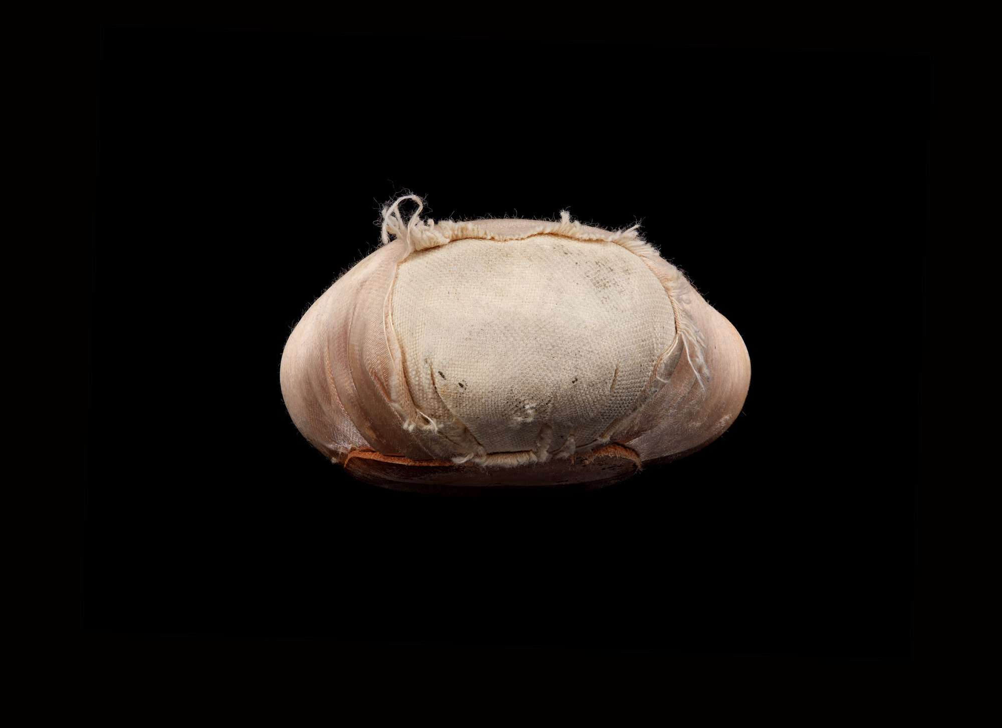 Close-up of the worn toe of a pink pointe shoe against a black background