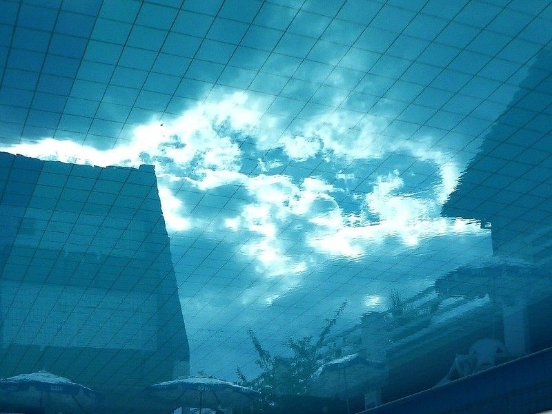 Picture of sky as if looking up from under water, with pool tiles reflected onto sky