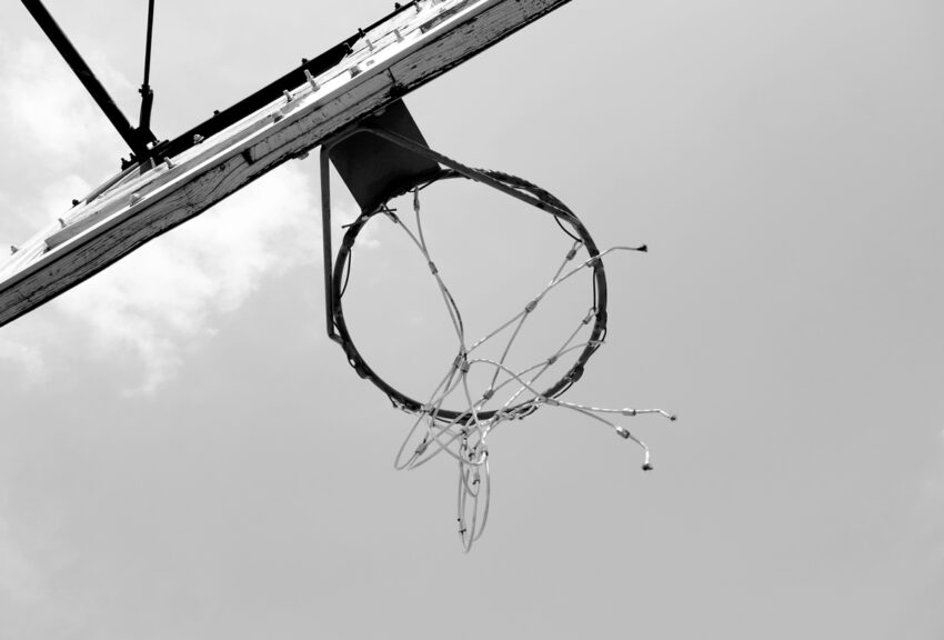 Black and white photograph of a basketball hoop shot upwards from below