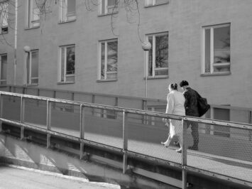 people walking in front of a building, black and whtie photo