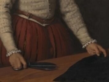 A tailor prepares fabric.