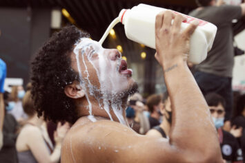 A man pouring milk in his eyes